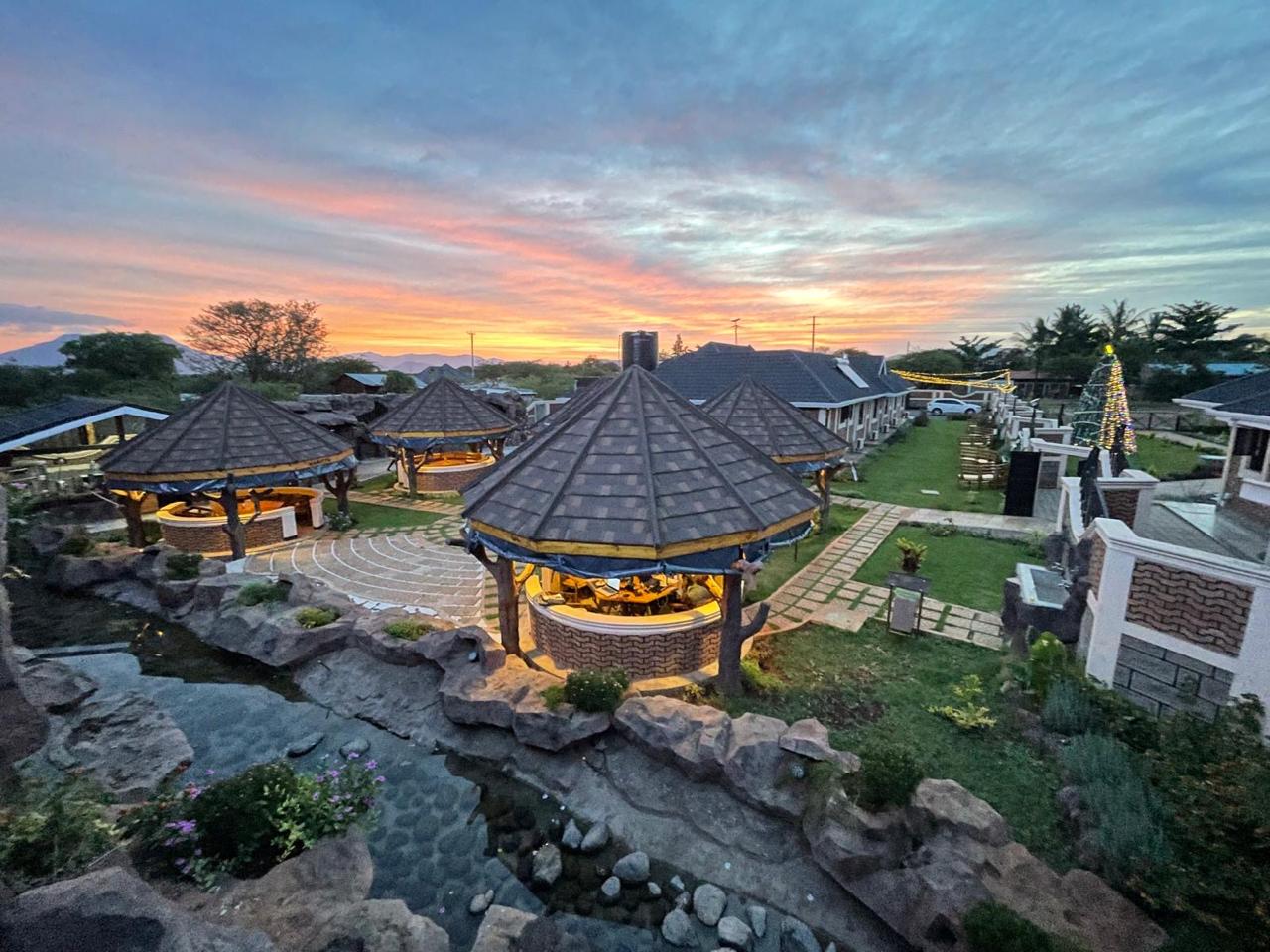 Aerial view of Mawimbi Jiko at sunset showing gazebos, lawns, guest rooms and stone paving